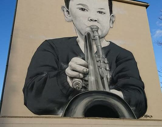 Fresque à Dreux de 12 mètre avec un enfant jouant de la trompette